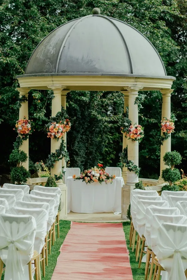 Kiosco de ceremonia con columnas y guirnaldas de flores
